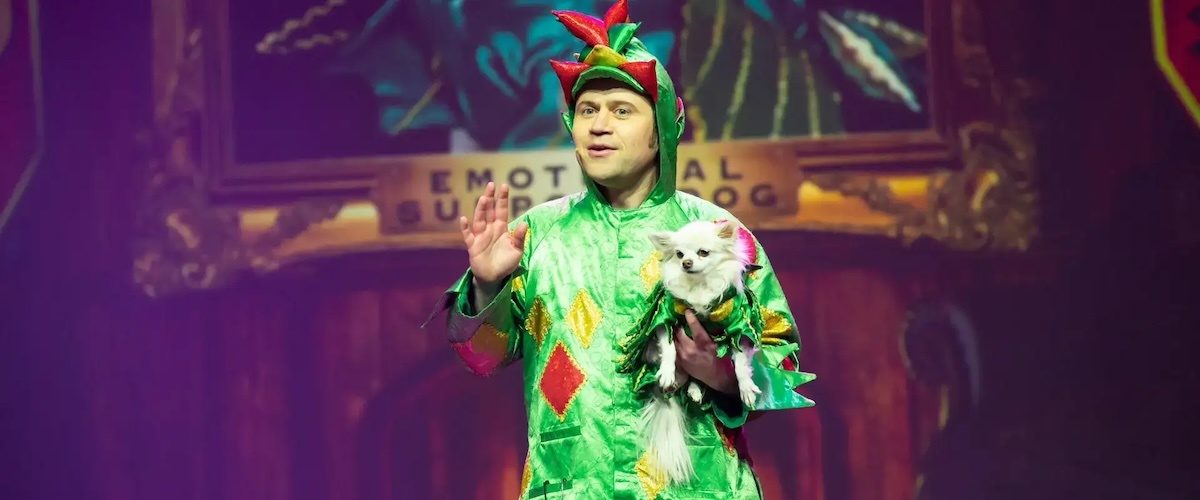 Piff the Magic Dragon holding his chihuahua, Mr. Piffles, on stage at the Flamingo