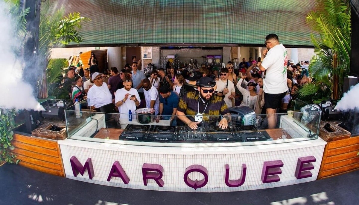 Deorro performing at Marquee Dayclub with the venue's sign in the foreground