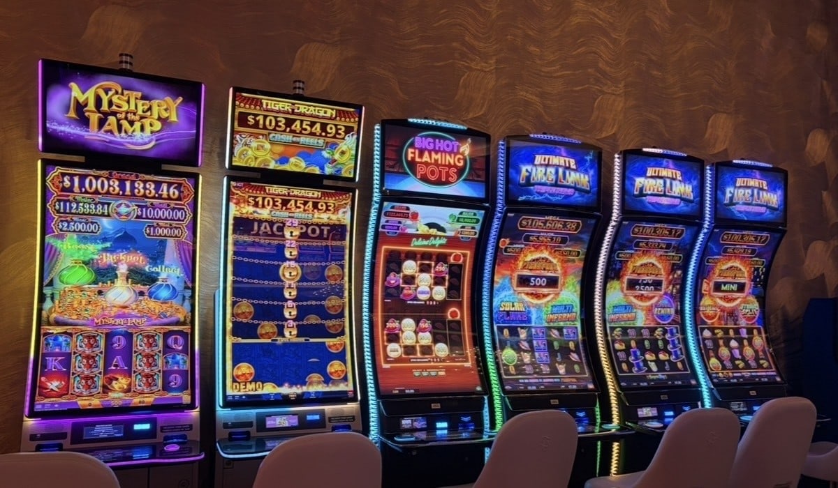 A row of high-limit slot machines, including Mystery of the Lamp and Ultimate Fire Link, inside the new Fontainebleau lounge