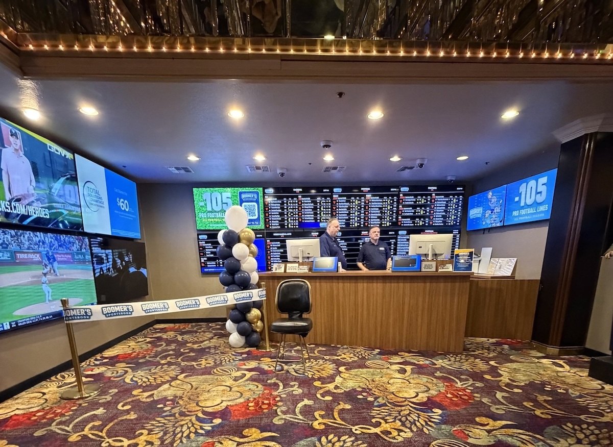 Staff members behind the counter at Boomer's Sportsbook's new location at Four Queens, decorated for its grand opening.