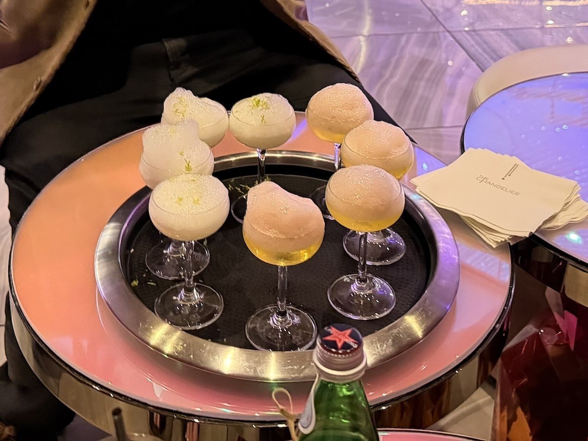 The Lime in the Coconut and Pineapple and Co. cocktails, both topped with foam, at Chandelier Bar