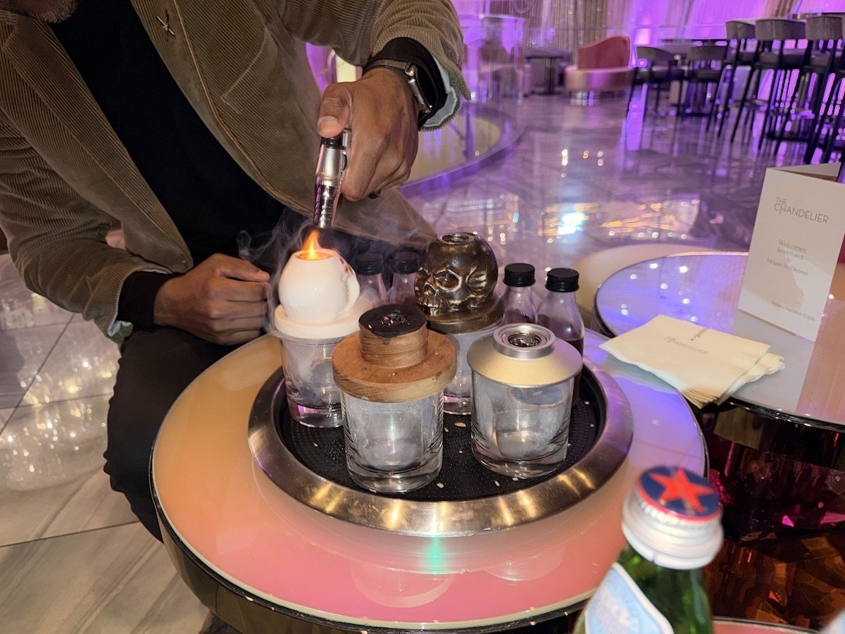 A server smokes wood over ice cubes before pouring the Rare Characters #2 cocktail at Chandelier Bar