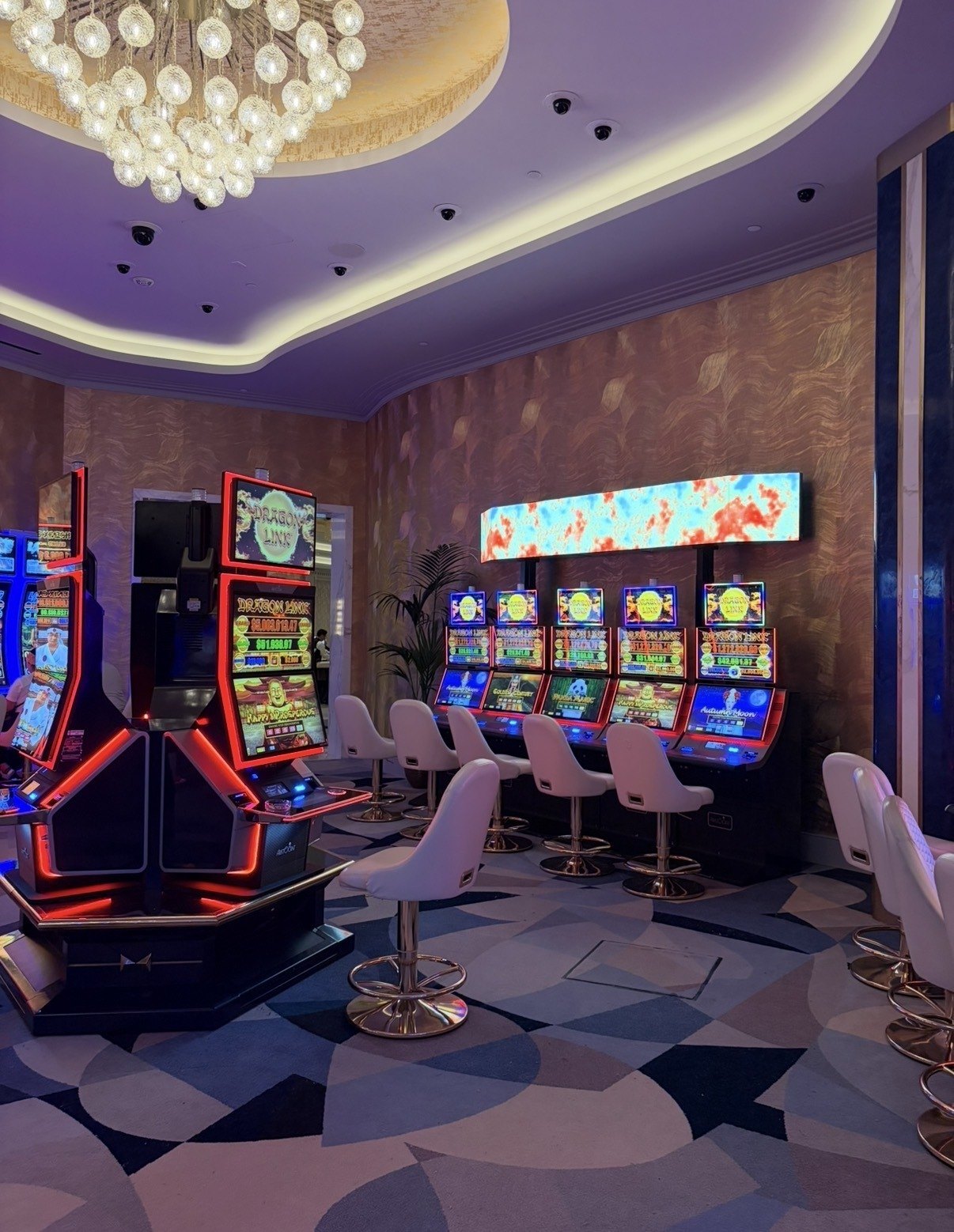 A row of Dragon Link high-limit slot machines glowing with red neon trim inside Fontainebleau's new lounge