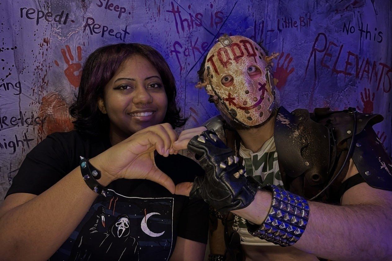 A guest poses with masked Haunted Inn character Todd at Palms Casino Resort