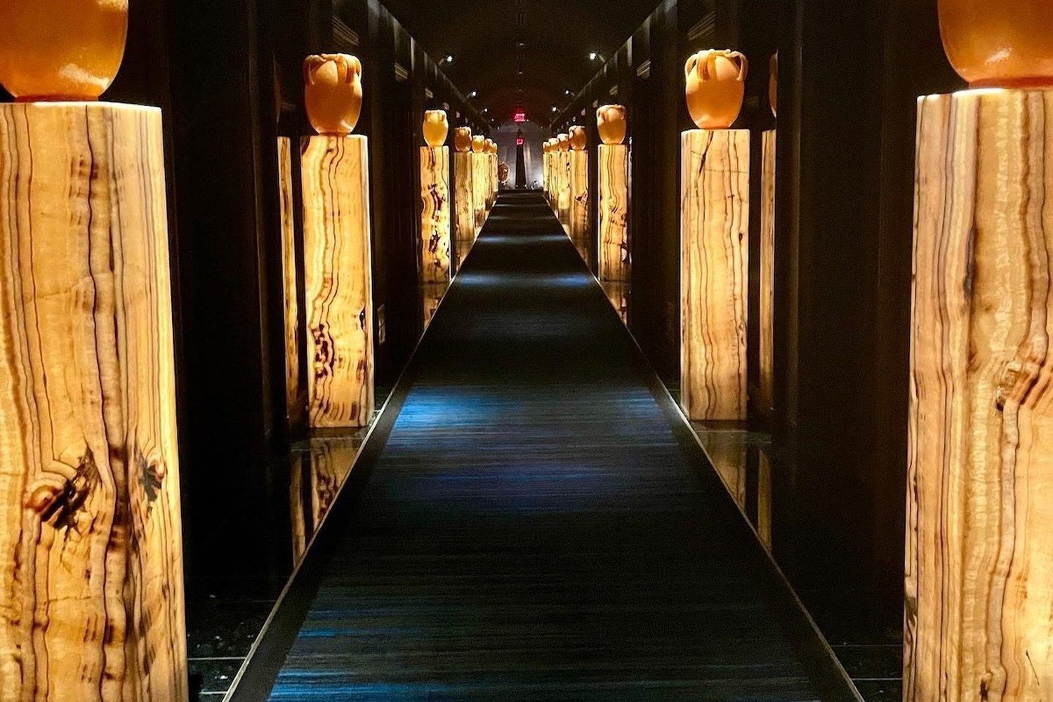 Hallway of lit onyx pedestals leading to the massage rooms at the Wynn Spa