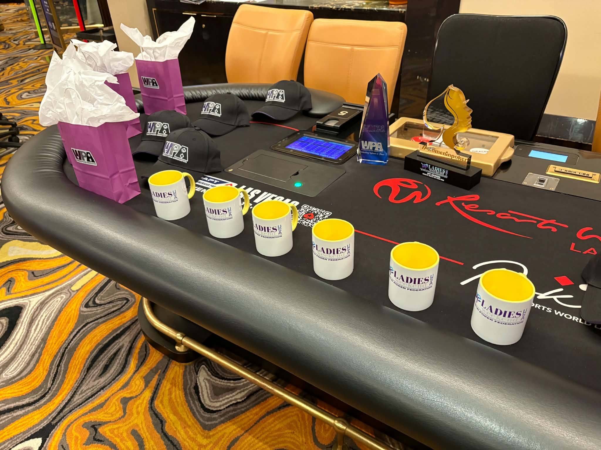 WPF Ladies Weekend swag bags, caps and mugs on a poker table