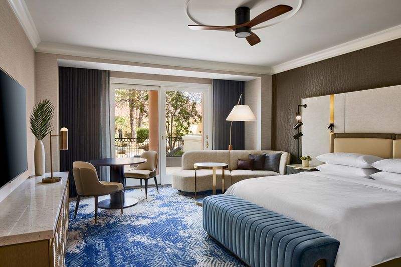Renovated King guest room at The Resort at Summerlin with patio overlooking landscaped gardens.