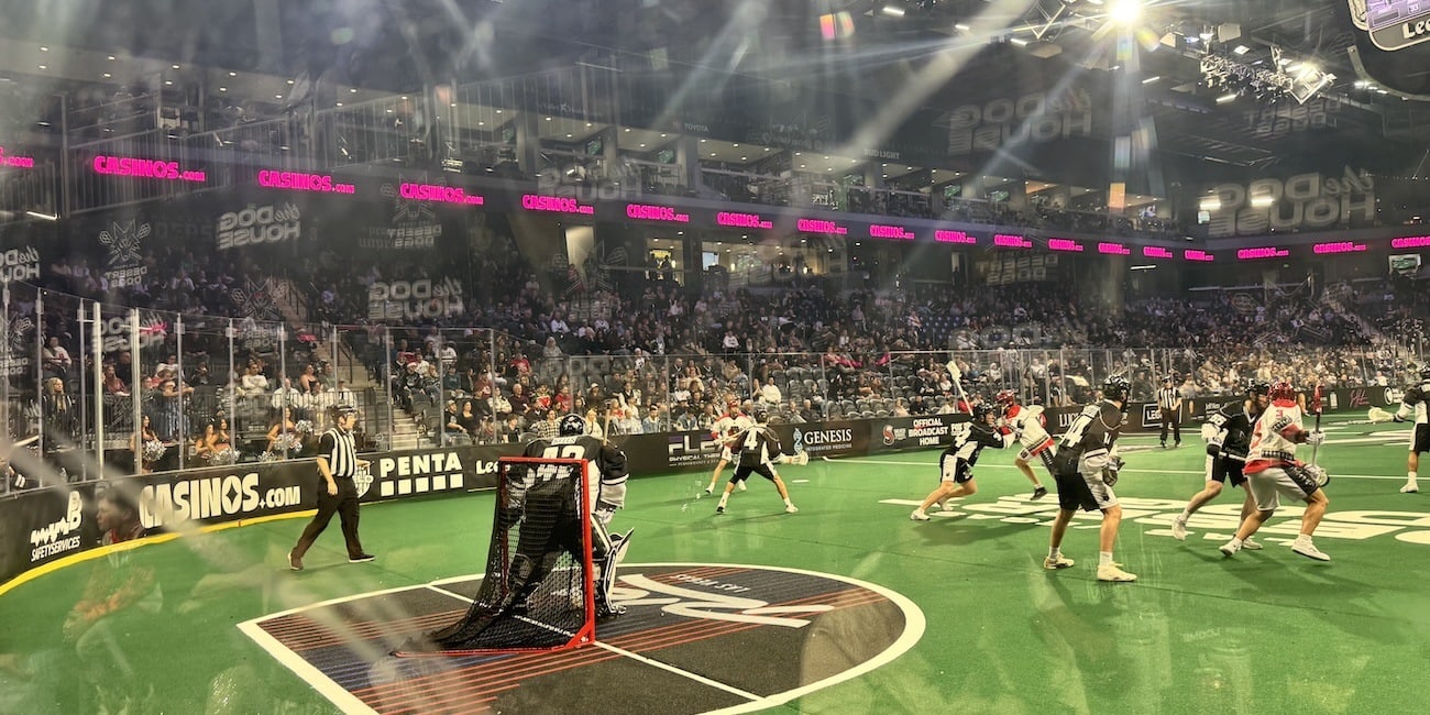 Field-level view from behind the Desert Dogs goal with Casinos.com’s pink-and-black banner wrapping around the arena