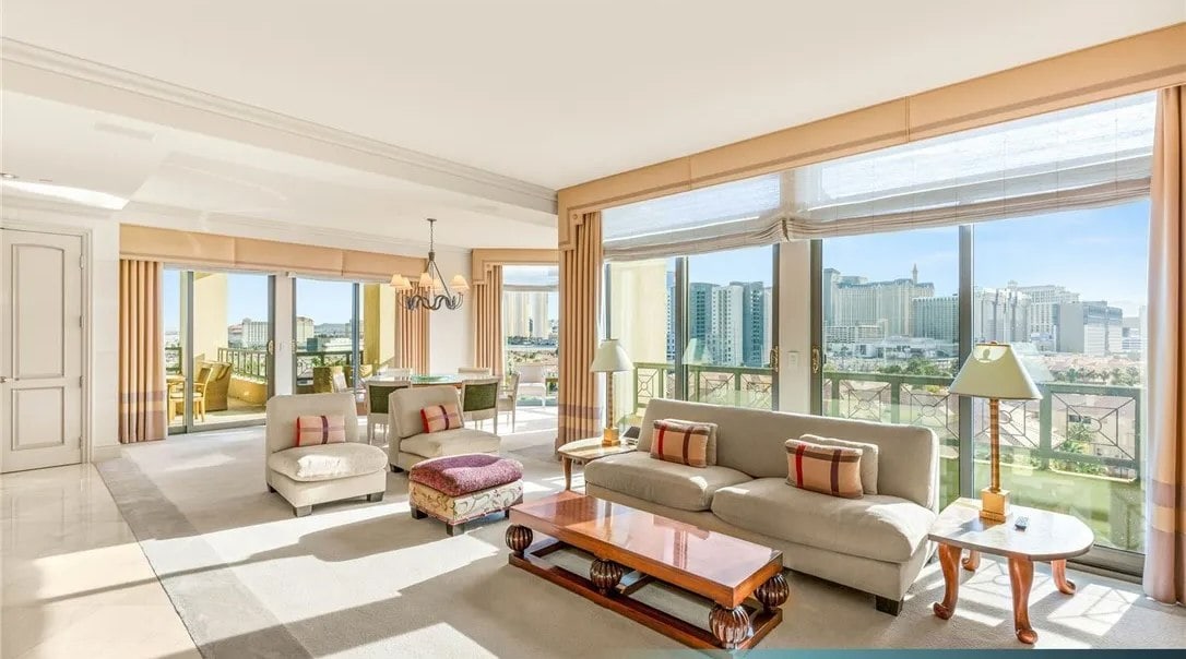 Interior view of a Park Towers condominium showing an open-concept living and dining area with floor-to-ceiling windows and views of the Las Vegas Strip, including Paris, Bellagio, and Caesars Palace.
