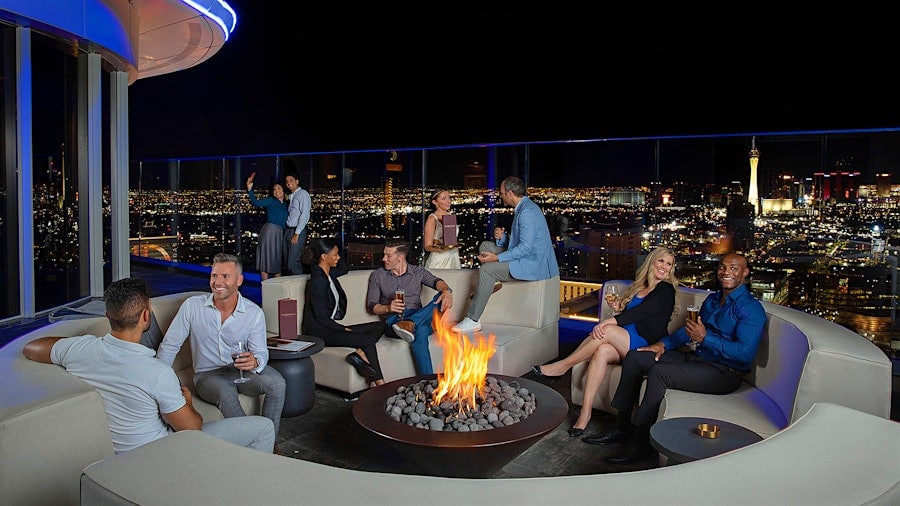 several guests sit at a circular booth surrounding a small fire at the Legacy club inside Circa in the downtown area of Las Vegas