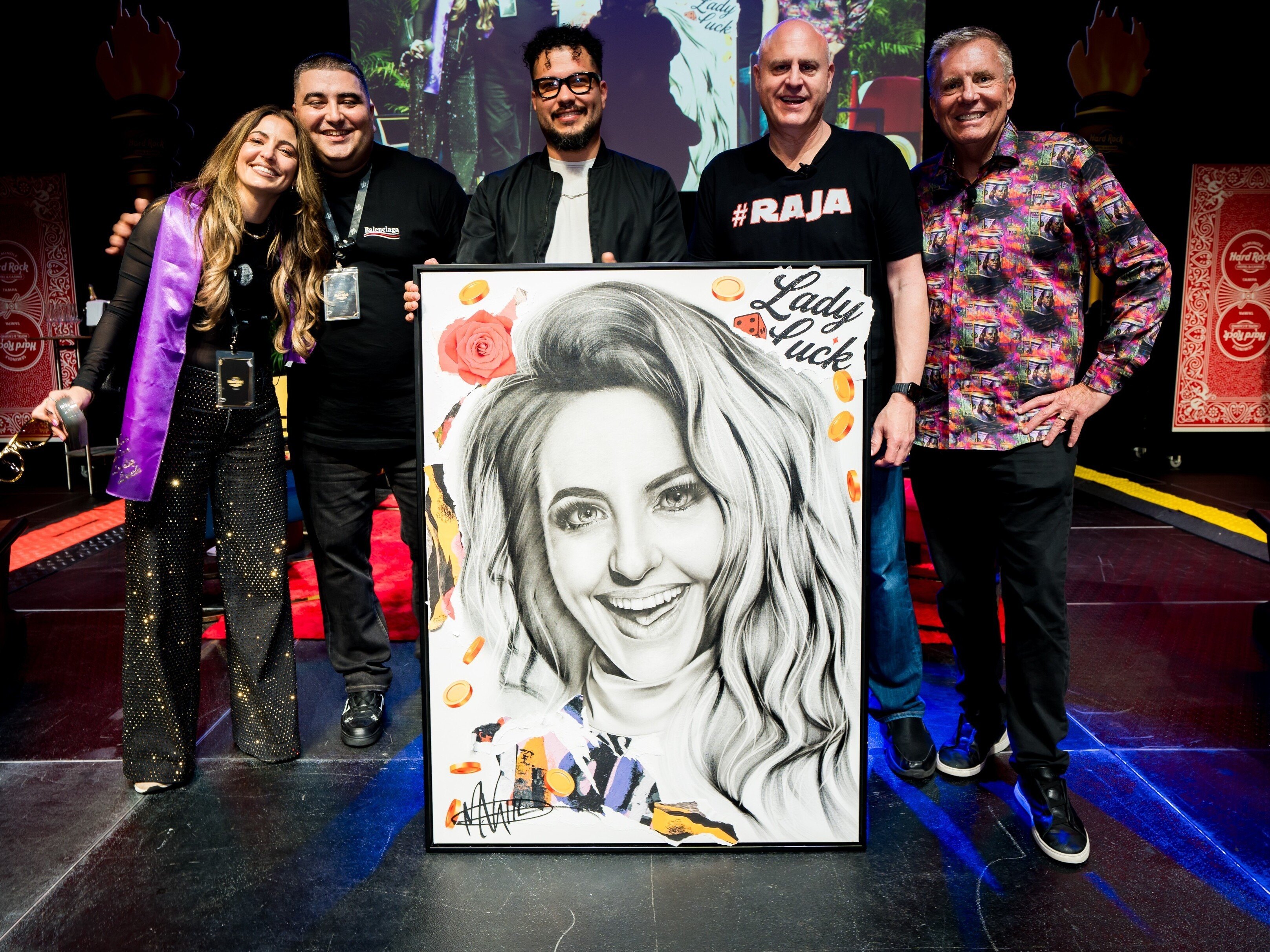 Influencers stand with a painting from Michael Vahl, made specifically for LadyLuckHQ's birthday