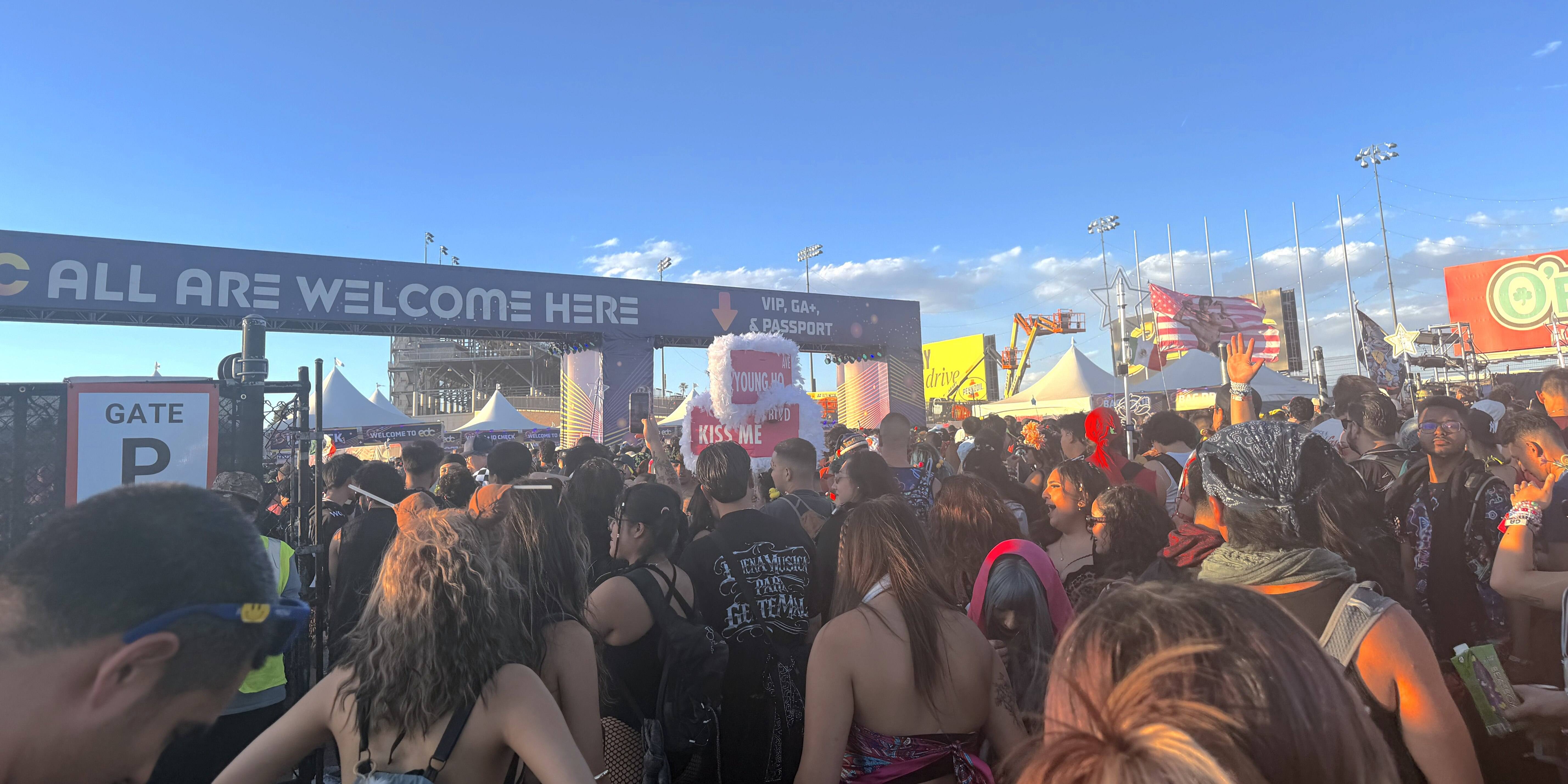  people stand at entrance to EDC waiting to enter into motor speedway)