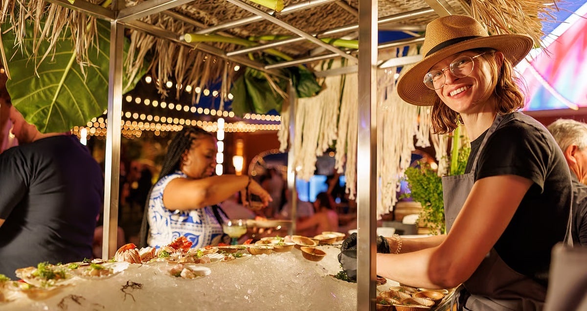 Sarah Thompson, Executive Chef at Casa Playa at Encore Las Vegas, smiles at the camera in front of a seafood display at Wynn Revelry.