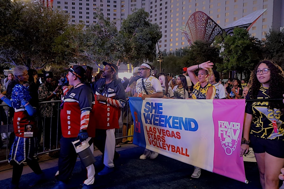 People walk in a parade holding a Las Vegas stars volleyball flag for Flavor Flav's SHE weekend.