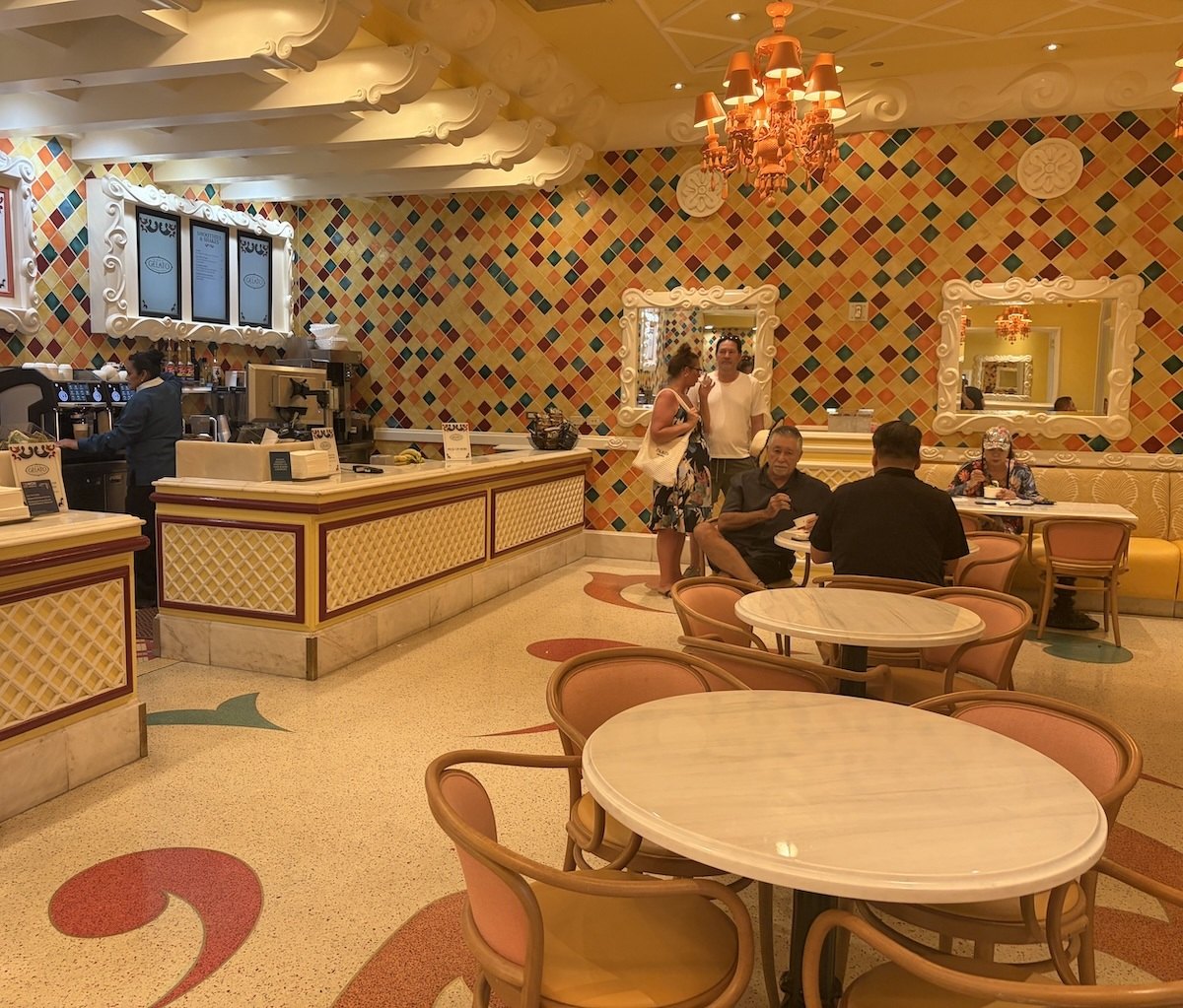 Interior seating area inside Café Gelato at Bellagio featuring colorful décor and café tables.