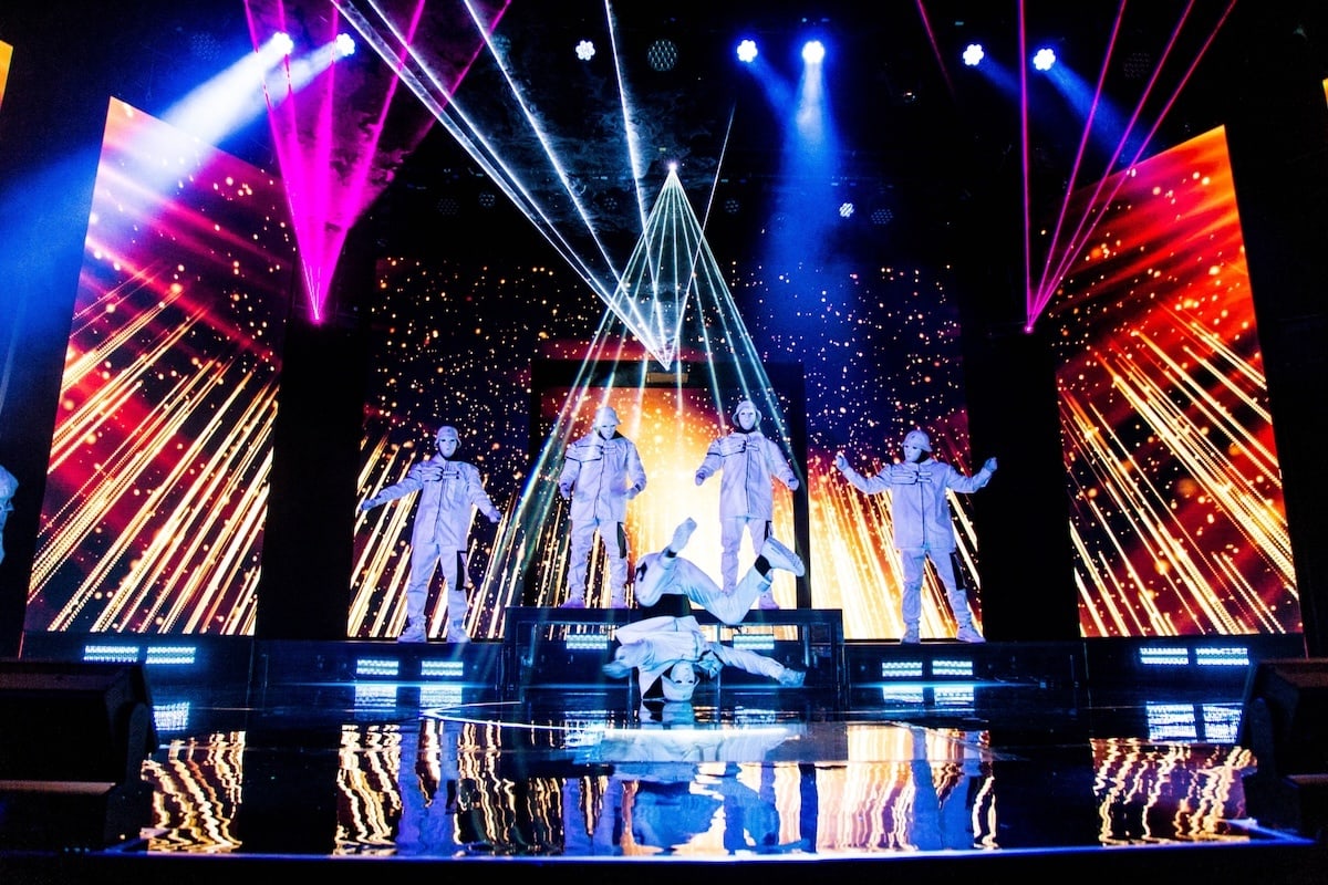 masked Jabbawockeez dance crew in white suits performing under laser lights at MGM Grand