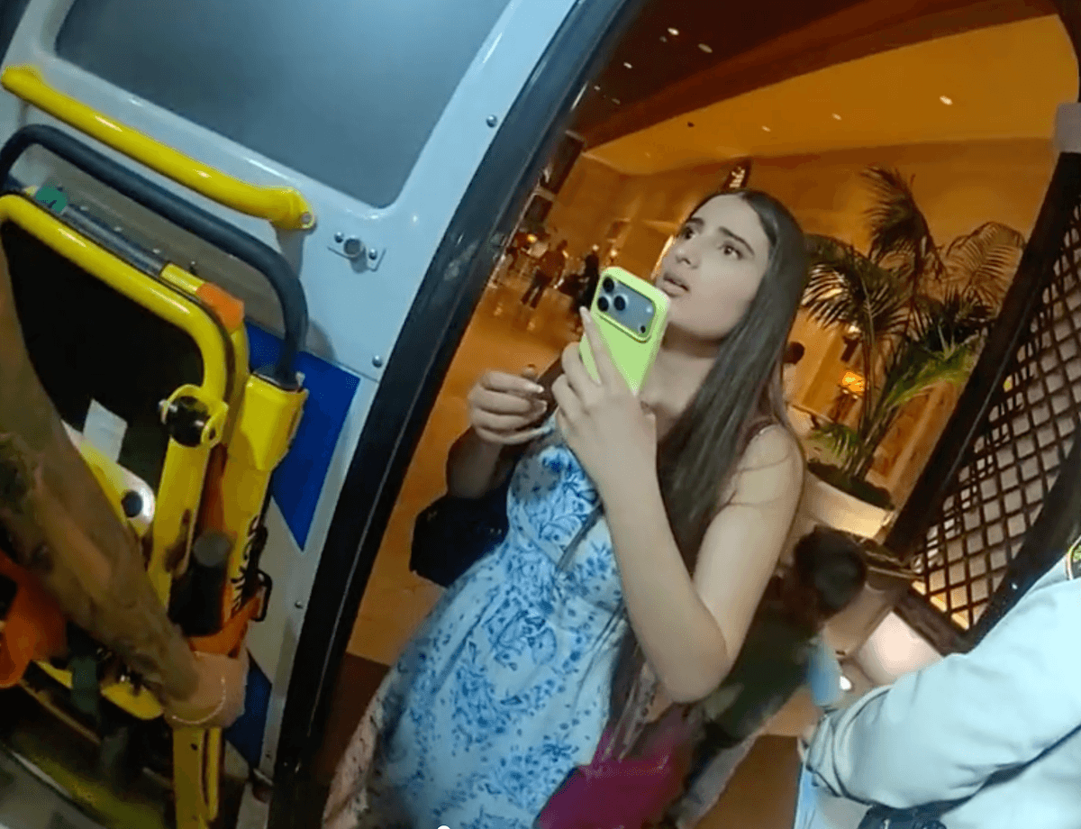 arpine misakyan's daughter stands at ambulance doors at encore valet asking police and medical personnel about her mom with a yellow phone in hand