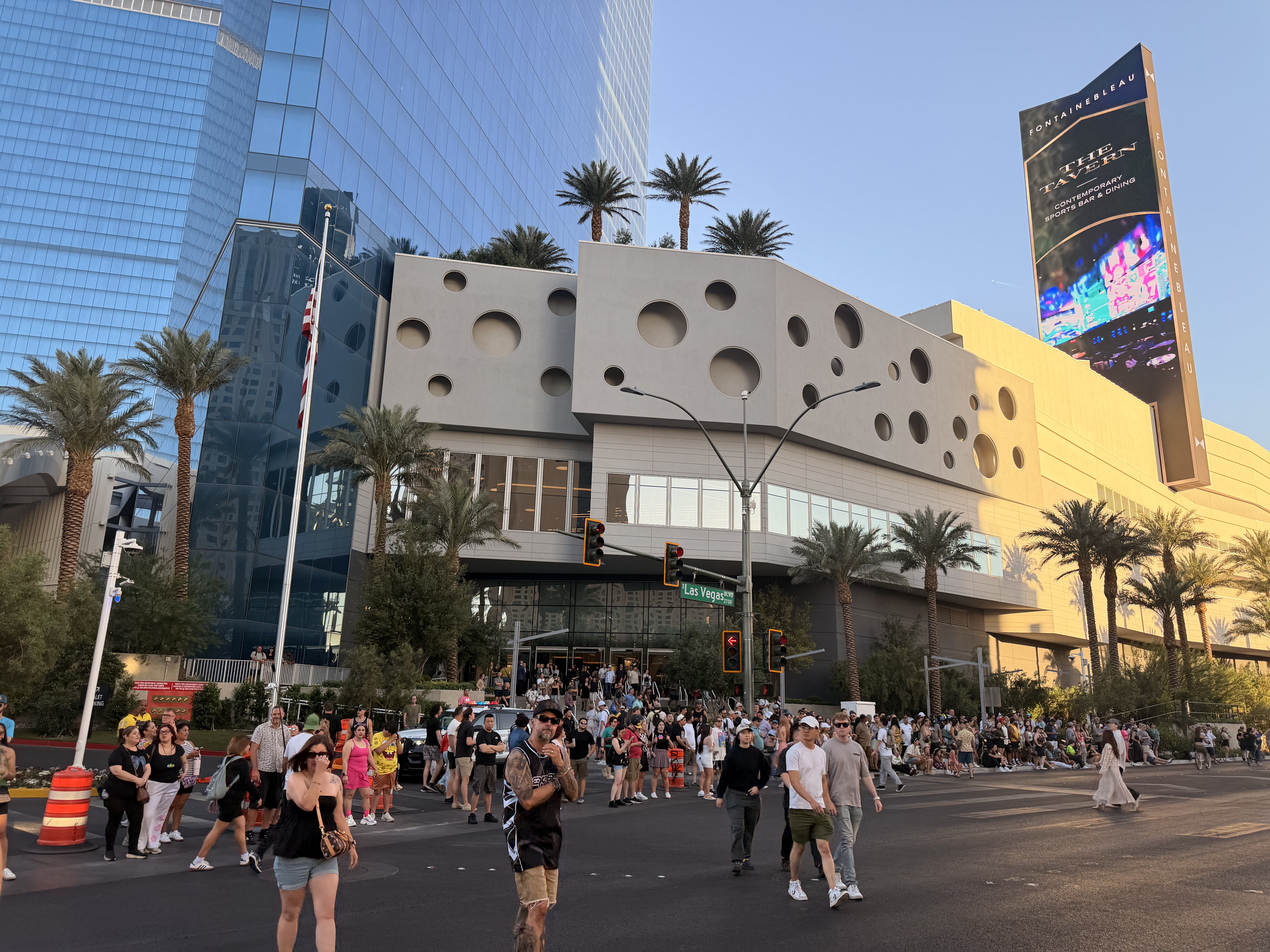 A large crowd of people stands outside the Fontainebleau Las Vegas during the EDC World Party Parade
