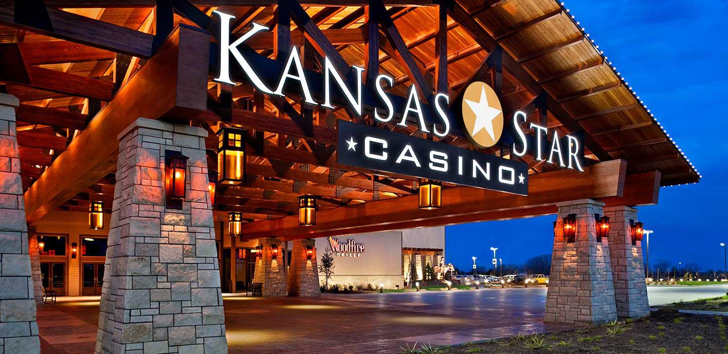 Kansas Star Casino entrance with illuminated wooden canopy, stone pillars, and warm lantern lighting at dusk
