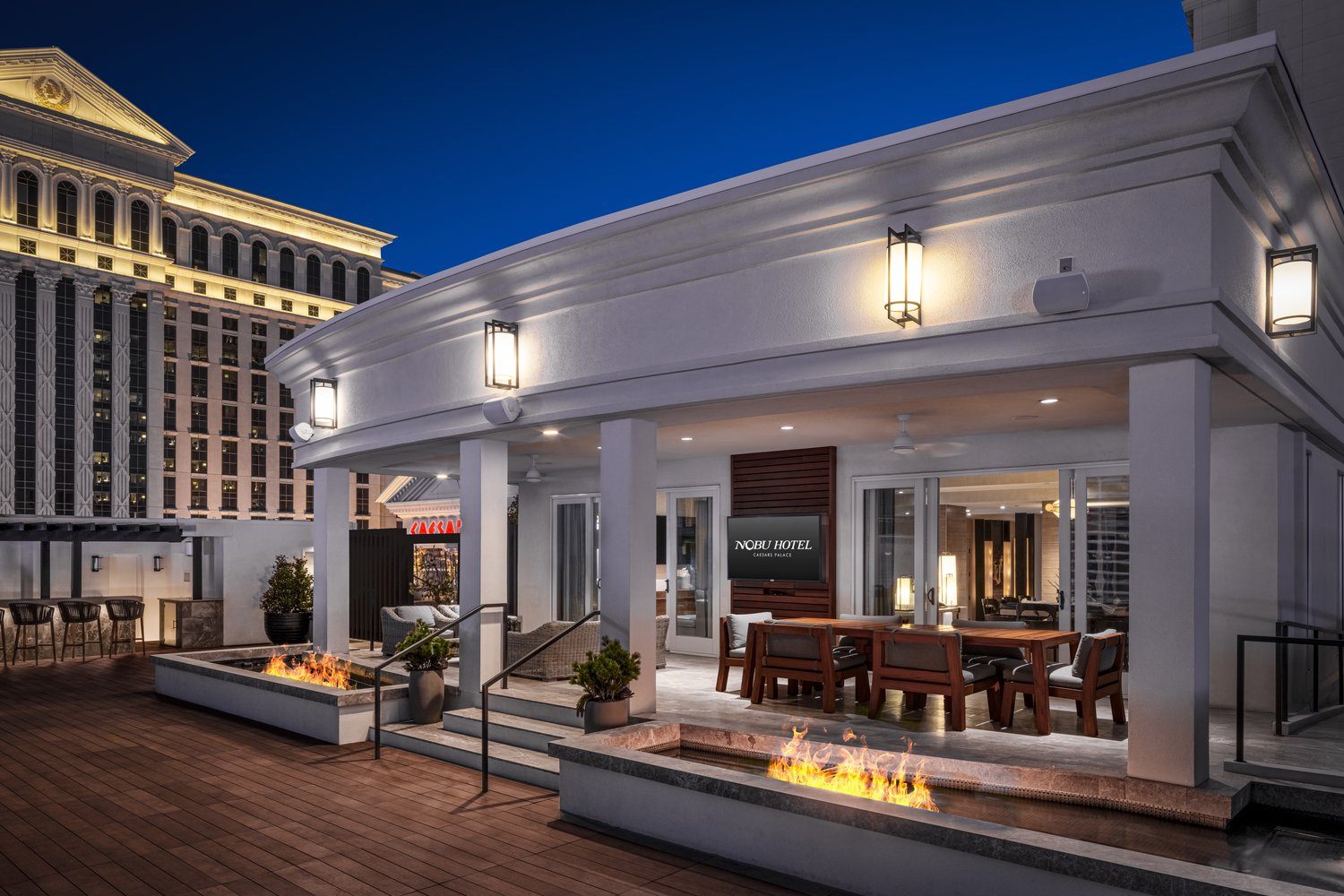 Nobu Villa rooftop terrace with fire pits and covered dining area at night